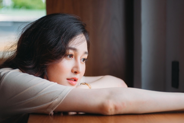 Tired woman in quiet moment reflecting on stress management and emotional wellbeing