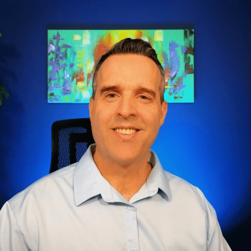 Christian mental health counselor smiling in a blue shirt with a colorful abstract painting in the background.